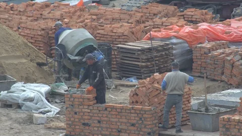 The builder puts a brick wall. the builder builds a brick wall.  build a house. Stock Footage 120674750