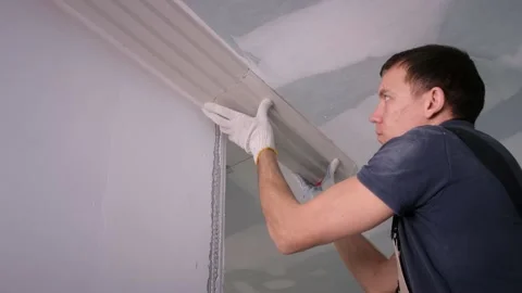 Builder puts fretwork on ceiling and makes marks with pencil Stock Footage 151784396