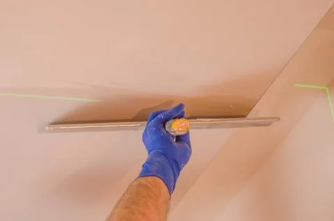 The Builder puts plaster on the wall.Hand holding a spatula with construction Stock Photos