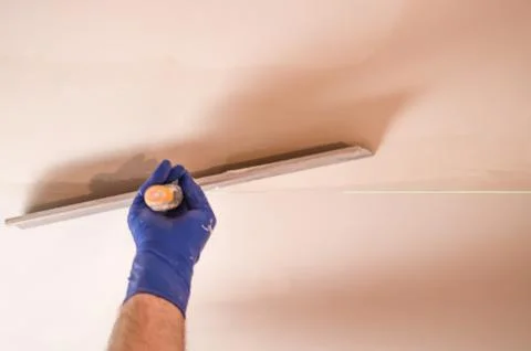 The Builder puts plaster on the wall.Hand holding a spatula with construction Stock Photos