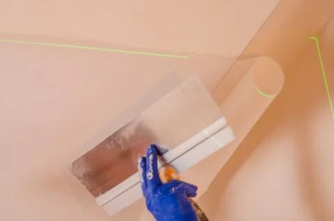 The Builder puts plaster on the wall.Hand holding a spatula with construction Stock Photos