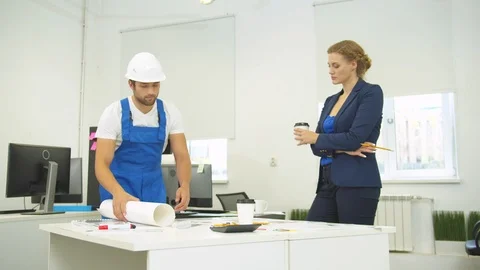 Builder puts whatman on table and discuss it with engineer Stock Footage 121815920