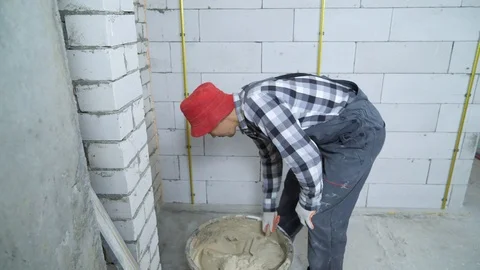 Builder putting plaster on aerated concrete block wall Stock Footage 102937083