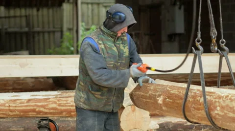 Builder raises wooden timber with Overhead Winch Crane. A man holds a log and Stock Footage 69043196