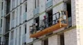 Builder in red hard hat on winch HD Footage