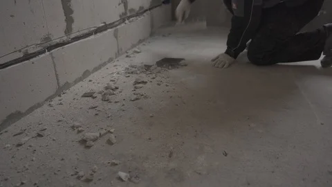 The builder removes the floor with a spatula after repair Stock Footage 101663297