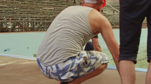 Builder removes overflow drainage grate from swimming pool Stock Footage 234320774