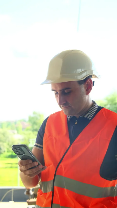 Builder review work documents on modern smartphone Stock Footage 317625395