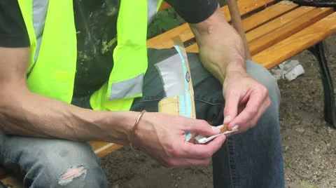 Builder rolls a cigarette Stock Footage 25169880