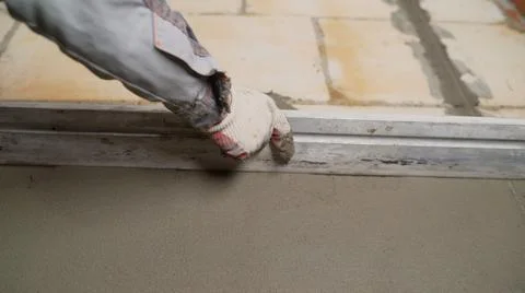 The builder is rubbing the wet mortar. Level the mortar on the wall. Renovati Stock Photos
