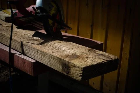Builder saws a board with a circular saw in the cutting a wooden plank Foto stock