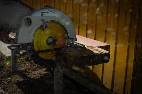 Builder saws a board with a circular saw in the cutting a wooden plank Foto stock
