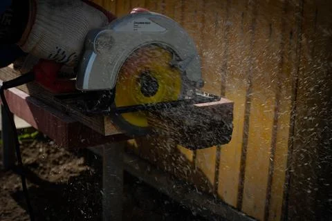 Builder saws a board with a circular saw in the cutting a wooden plank Stock Photos
