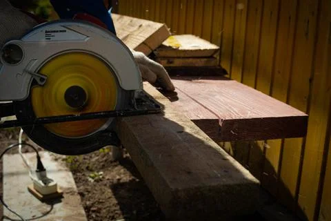 Builder saws a board with a circular saw in the cutting a wooden plank Foto stock