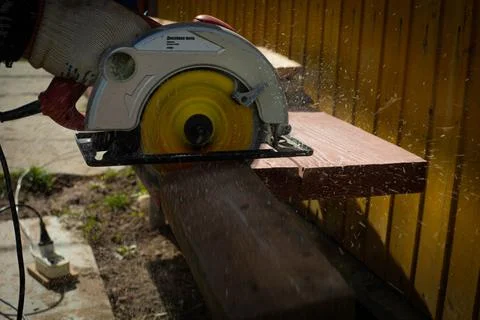 Builder saws a board with a circular saw in the cutting a wooden plank Foto stock