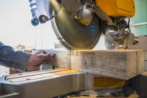 Builder saws a board with a circular saw in the cutting a wooden plank Stock Photos