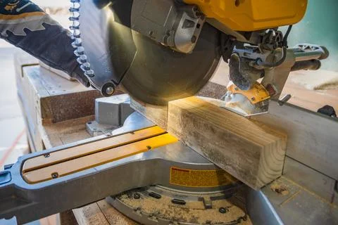 Builder saws a board with a circular saw in the cutting a wooden plank Stock Photos
