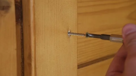 The builder screws in the self-tapping screw with a screwdriver. Stock Footage 156815278