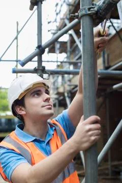 Builder On Site Putting Up Scaffolding Foto stock