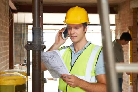 Builder On Site Using Mobile Phone Stock Photos