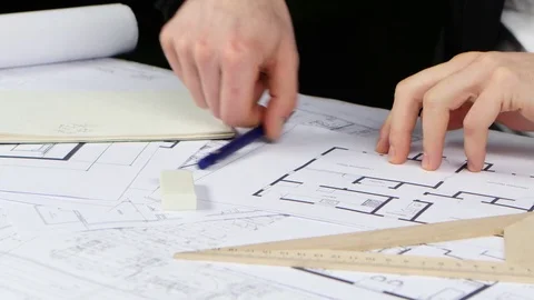 Builder sits at the table and analyzes the drawing of the new store. Close up Stock Footage 73681457