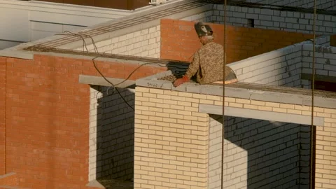 Builder sits on a tall building welding a metal structure. Construction Stock Footage 138988467