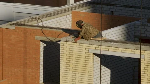 Builder sits on a tall building welding a metal structure. Construction Stock Footage 139305958