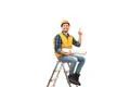 The builder sitting on the ladder and gesturing on the white background Photo