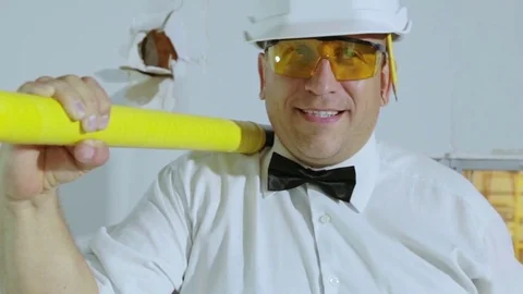 The builder with a sledgehammer and a pencil goes to the camera. Video stock 81354558