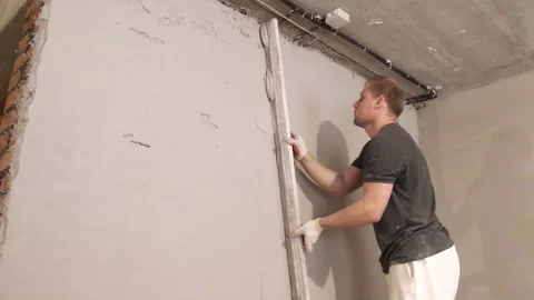 Builder Slowly Levels Building Compound. Construction Works. Painter. Stucco Stock Footage 168357646