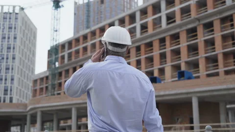Builder with smartphone at construction site. Foreman with work documentation in Vídeos de archivo 111770405