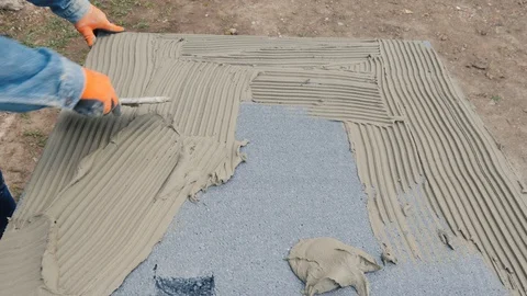 Builder smears insulation sheet with glue Stock Footage 129333725