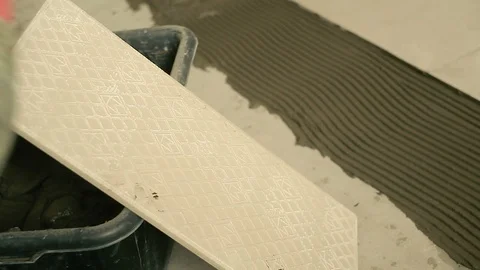 Builder smears the solution on the tile Видео 88979891