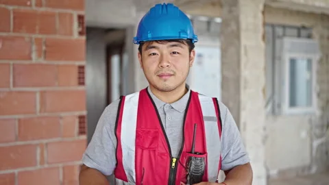 Builder smiling confident taking out glasses at construction site Video stock 247386789