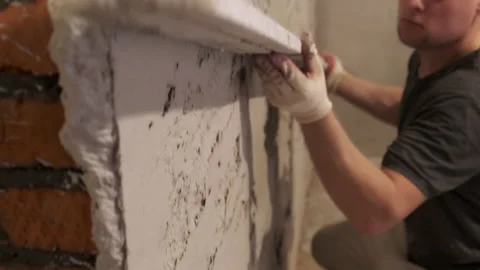 Builder Smoothing Plaster on Wall. Aligning Wall. Preparation for Fine Finishing Stock Footage 168357218