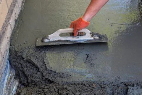 Builder smoothing the surface of screed Stock Photos