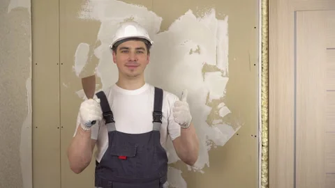 A builder with a spatula in his hand looks at the camera and shows the class and Vidéo 152036511