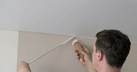 Builder with special spatula inserts edge of ceiling into seam connection Stock Footage 131035305