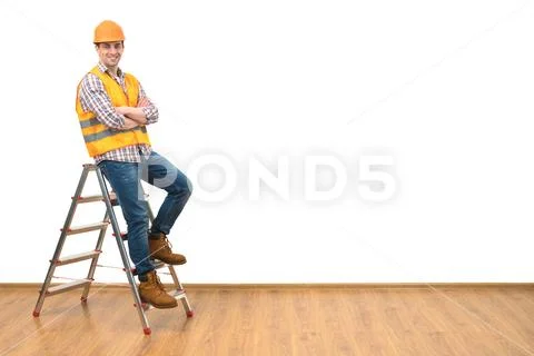 The builder standing on the ladder on the white wall background Stock Photos