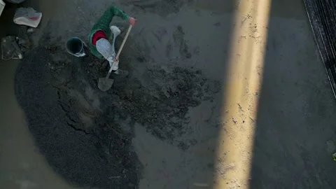 Builder stirs concrete with a shovel, on a large construction site Video stock 224045891