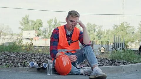 Builder suffering from fatigue and overwork on building site Stock Photos