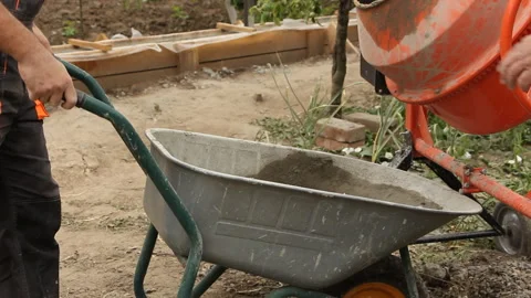 A builder takes away a construction wheelbarrow Stock Footage 247065805