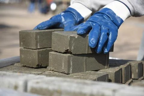 The builder takes the bricks, close-up. Stock Photos
