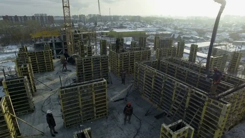 Builder takes the construction hose with the cement and brings it to the slots Stock Footage 82016525