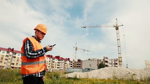 The builder is talking on the walkie-talkie on the background of the Stock Footage 129164127