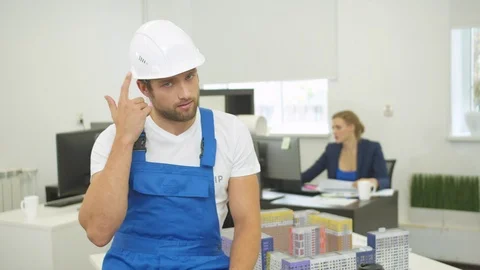 Builder tells something on the camera and shows his uniform Stock Footage 121816242