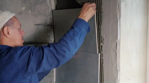 Builder tiling a wall in a construction concept Video stock 142106141