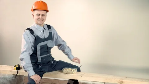 The builder is tired and ready to taste the delicious lunch. Building snack Stock Footage 102776880