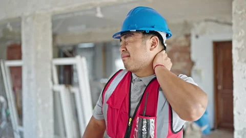 Builder tired standing with serious expression at construction site Video stock 247386818