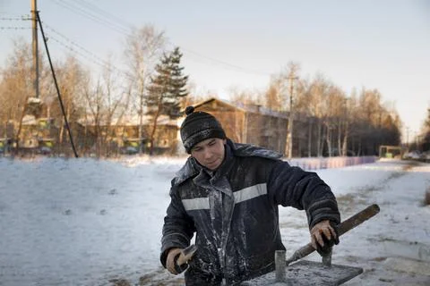 Builder with a tool in his hands at the construction site of the ice town 스톡 사진